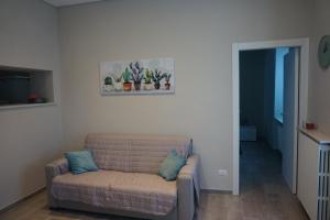 un soggiorno con divano e un dipinto sul muro di il Loft a Cuneo