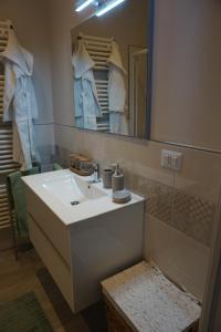 bagno con lavandino bianco e specchio di il Loft a Cuneo