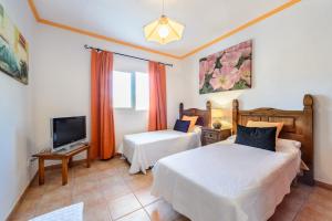 サン・カルレス・デ・ペラルタにあるVilla Can Amelerのベッド2台とテレビが備わるホテルルームです。