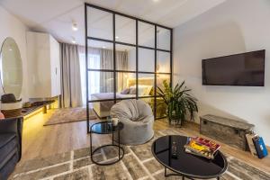 a living room with a couch and a tv at Glossy Lodge in Thessaloniki