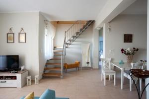een woonkamer met een trap en een tafel bij Nicopolis Villa in Vráchos