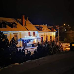ein großes weißes Haus mit Lichtern in der Nacht in der Unterkunft Penzion U Jana in Výprachtice