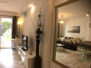 - un salon avec un miroir et un canapé dans l'établissement Rio Marina apartment, à Nerja
