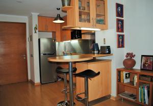 cocina con barra y nevera de acero inoxidable en Studio Apartment En Providencia, en Santiago