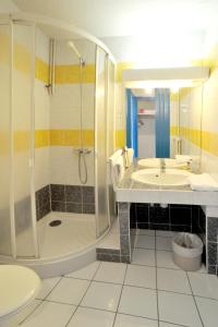 a bathroom with a sink and a shower and a toilet at Hôtel Le Sully La Roche Sur Yon in La Roche-sur-Yon