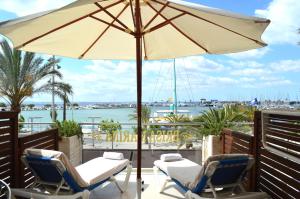 a patio with two chairs and an umbrella at Hostal Brisa Marina in Port d'Alcudia