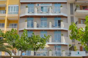 an apartment building with trees in front of it at Hostal Brisa Marina in Port d'Alcudia