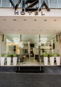 uma frente de loja com grandes potes brancos de plantas em Hotel Viza em Arequipa