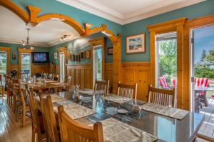 uma sala de jantar com paredes verdes e mesas e cadeiras de madeira em Heartwood Inn em Drumheller