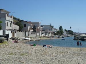 a group of people laying on a beach near the water at B&B Arcobaleno in Pellaro