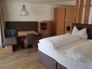 a bedroom with a bed and a table and a chair at Hotel Restaurant Schaurhof in Vipiteno