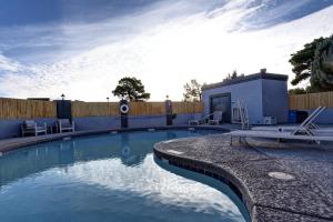 普雷斯科特山谷的住宿－普雷斯科特谷綠樹酒店，一个带两把椅子和围栏的游泳池