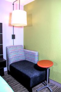 Habitación con silla, mesa y lámpara en Holiday Inn Express Rochester - Greece, an IHG Hotel, en Rochester