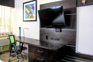 an office with a desk with a tv on a wall at Holiday Inn Express Rochester - Greece, an IHG Hotel in Rochester