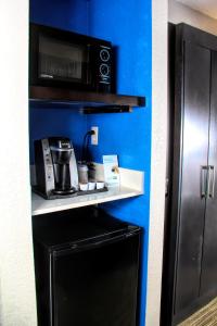 a kitchen with a microwave and a black refrigerator at Holiday Inn Express Rochester - Greece, an IHG Hotel in Rochester