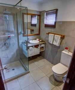 a bathroom with a shower and a toilet and a sink at Seaview Lodge and Restaurant in Nuku‘alofa