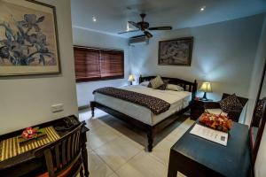 um quarto com uma cama e uma secretária e uma cama sidx sidx em Seaview Lodge and Restaurant em Nuku‘alofa