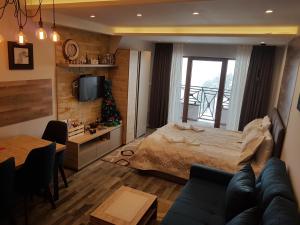 a bedroom with a bed and a living room at Ogi & Una Premijer 42 in Kopaonik