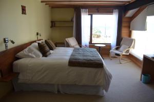 a bedroom with a large bed and a large window at Puerto Austral in Puerto Varas