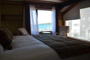 a bedroom with a large bed with a view of the ocean at Puerto Austral in Puerto Varas