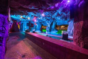 um quarto numa caverna com luzes roxas e verdes em The Island Resort at Fort Walton Beach em Fort Walton Beach