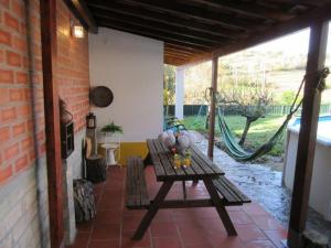 um pátio com uma mesa de madeira e uma rede de descanso em Quintal do Freixo - Country House em Sobral de Monte Agraço