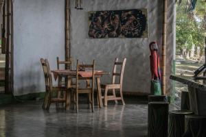 comedor con mesa de madera y sillas en La Leona Eco Lodge, en Carate