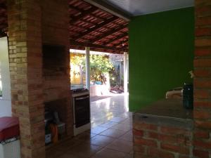 a kitchen with green walls and a brick oven at Casa das flores in Itapoa