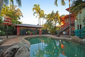 
a beach with a pool and palm trees at Travellers Oasis in Cairns

