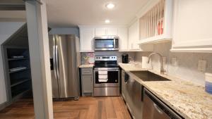 a kitchen with white cabinets and stainless steel appliances at Southwest, NRG, GRB, MM Park, Downtown, Galleria, Medical Center - Imogene in Houston