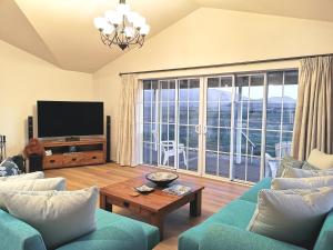 a living room with a tv and a couch and a table at Kahurangi Twizel Hosted Bed & Breakfast in Twizel