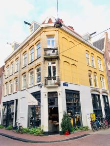 a yellow and white building on a city street at Bee Amsterdam - central apartment in the trendy Jordaan in Amsterdam