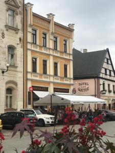 ein großes Gebäude mit Autos auf einem Parkplatz in der Unterkunft Pension Ulrika in Loket