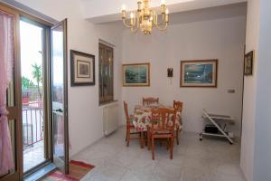 a dining room with a table and chairs and a chandelier at Rosa di Calabria in Bovalino Marina
