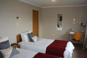 a hotel room with two beds and a chair at Jenny's Bed & Breakfast in New Plymouth