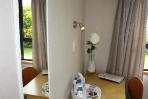 a room with a table with a vase of flowers on it at Jenny's Bed & Breakfast in New Plymouth