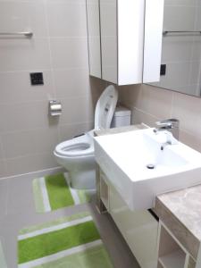 a bathroom with a white toilet and a sink at Highvill AST in Astana