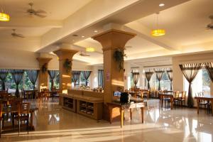 a restaurant with wooden tables and chairs and windows at Guanziling Lin Kuei Yuan Hot Spring Resort in Baihe