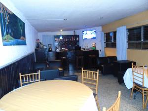 a room with a table and chairs and a bar at El Centro Hotel in Quetzaltenango