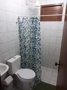 a bathroom with a toilet and a shower curtain at Casa de Praia em Carneiros in Tamandaré