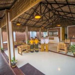 a group of people standing in a large room at Hotel Queen Jamadevi in Mawlamyine