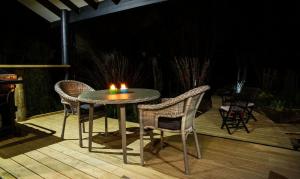 stół z 2 krzesłami i świeca na tarasie w obiekcie Night Sky Cottage w mieście Ohakune