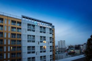 a building with a sign on the top of it at New Songtan Hotel in Pyeongtaek