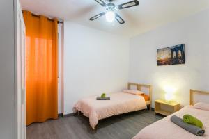 sypialnia z 2 łóżkami i wentylatorem sufitowym w obiekcie Lovely, new, bright 3 mins to beach apt 105 sq meters w Alicante