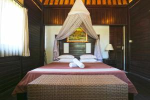 ein Schlafzimmer mit einem großen Bett mit Baldachin in der Unterkunft Mega Cottages in Nusa Lembongan