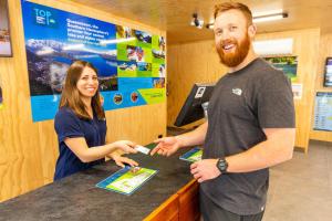 un hombre y una mujer parados en una caja registradora en Apartments at Queenstown TOP 10 Holiday Park, en Queenstown