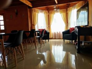 ein Wohnzimmer mit Stühlen, einem Tisch und einem Fenster in der Unterkunft Paraiso Patagonico in Chaitén