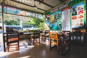 a restaurant with tables and chairs and a menu at Khaosok Secret Hostel in Khao Sok National Park