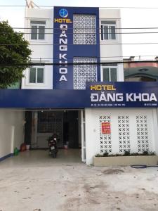 un hôtel dansant khovota avec une moto garée devant. dans l'établissement Khách sạn Đăng Khoa, à Cao Lãnh