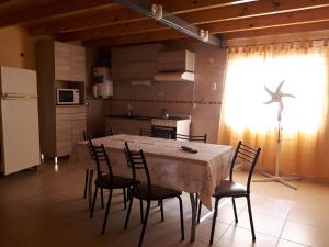 a kitchen with a table and chairs in a room at Departamentos San Expedito in Malargüe